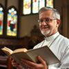 Ksiądz z otwartą Biblią podczas modlitwy w kościele
